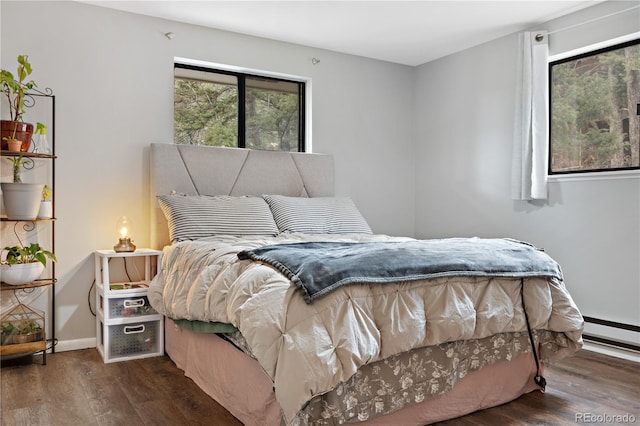 bedroom with a baseboard radiator, baseboards, and wood finished floors