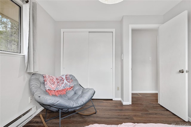 sitting room with baseboards, baseboard heating, and wood finished floors