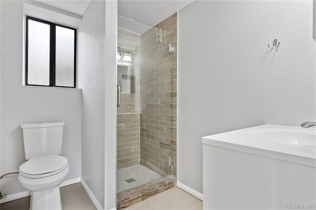 full bathroom featuring baseboards, a stall shower, a sink, tile patterned flooring, and toilet