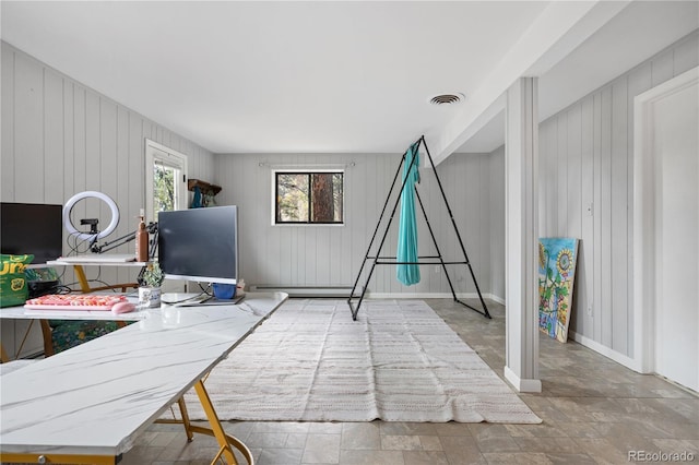 office area featuring visible vents, baseboards, and stone finish floor