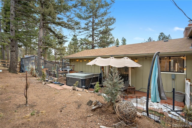 back of house featuring a patio area, a hot tub, and fence