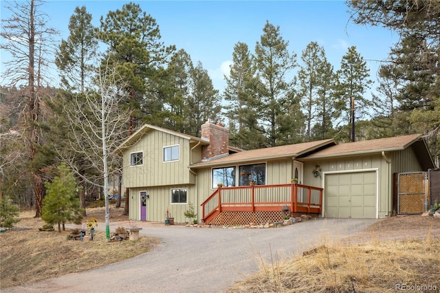 split level home with an attached garage, a chimney, board and batten siding, and dirt driveway