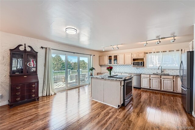 4090 S Tamarac Dr, Denver, CO 80237 - kitchen featuring stainless steel appliances, a sink, dark wood-type flooring, light stone countertops, and a center island