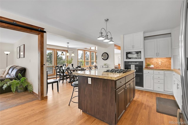 27100 Molly Dr, Conifer, CO 80433 - kitchen featuring black appliances, white cabinetry, light wood-style floors, and backsplash