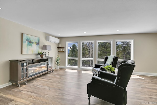 27100 Molly Dr, Conifer, CO 80433 - living room featuring a wall mounted AC, baseboards, wood finished floors, recessed lighting, and a glass covered fireplace