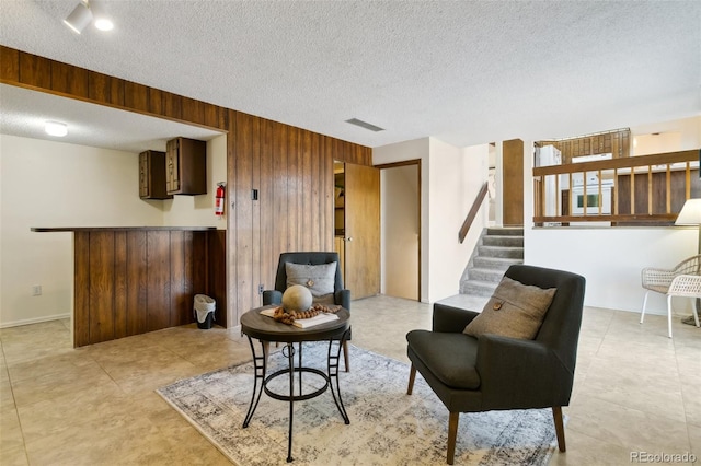 6750 Lange, Colorado Springs, CO 80918 - living area featuring a textured ceiling and wood walls