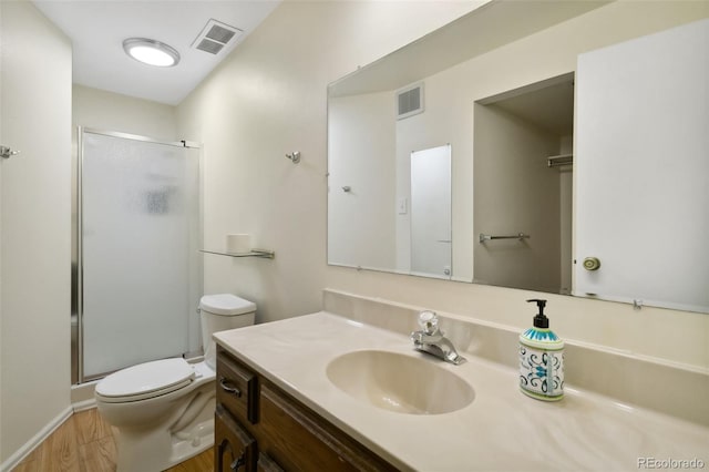 6750 Lange, Colorado Springs, CO 80918 - bathroom with a shower with door, vanity, hardwood / wood-style flooring, and toilet