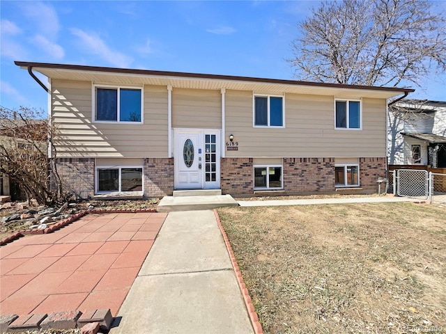 raised ranch with fence and brick siding