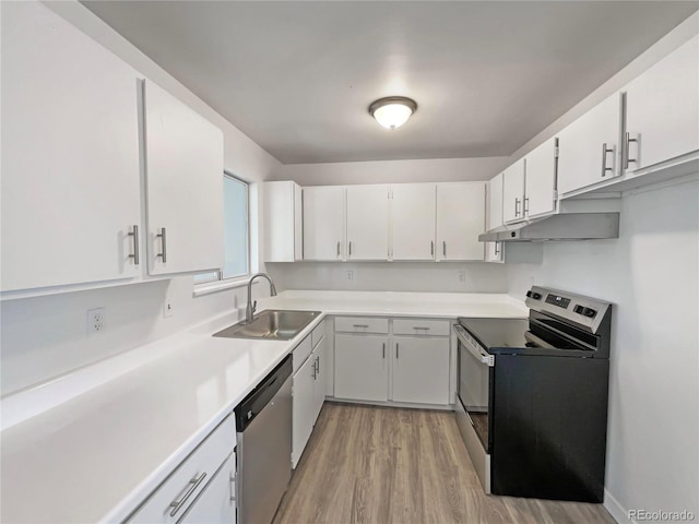 kitchen featuring appliances with stainless steel finishes, white cabinetry, a sink, light wood-type flooring, and under cabinet range hood