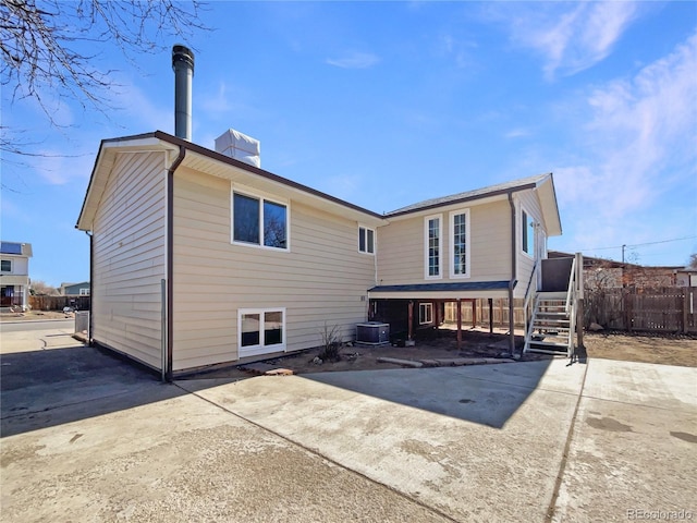 rear view of house with fence and central air condition unit