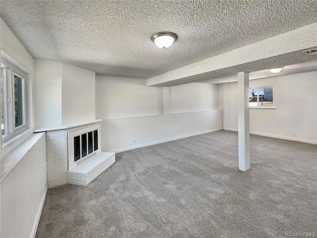 below grade area featuring carpet floors, a fireplace, and a textured ceiling