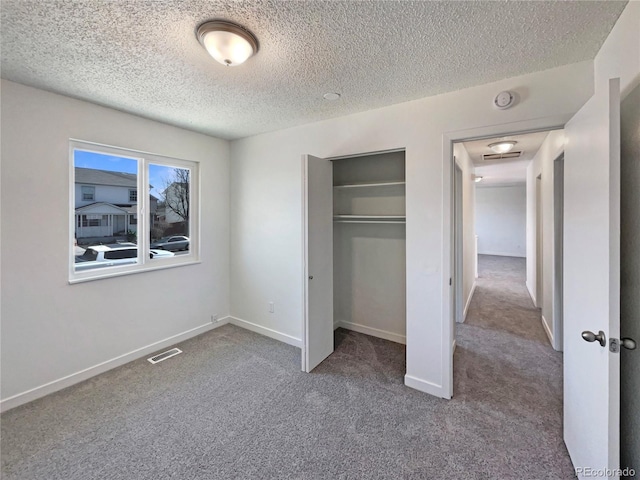 unfurnished bedroom featuring baseboards, carpet, visible vents, and a closet