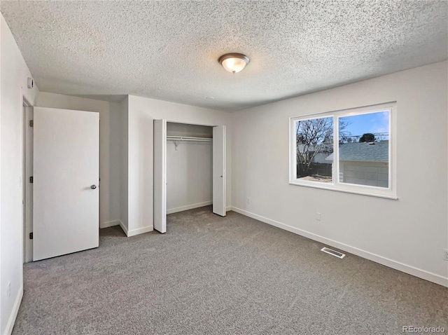 unfurnished bedroom with carpet, a closet, visible vents, and baseboards