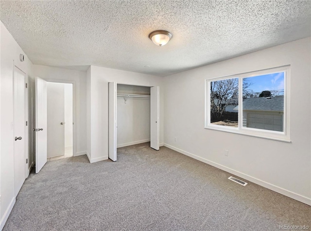 unfurnished bedroom featuring carpet floors, baseboards, visible vents, and a closet