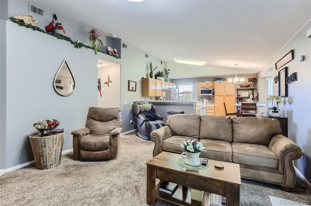 living room featuring carpet floors, a notable chandelier, and lofted ceiling