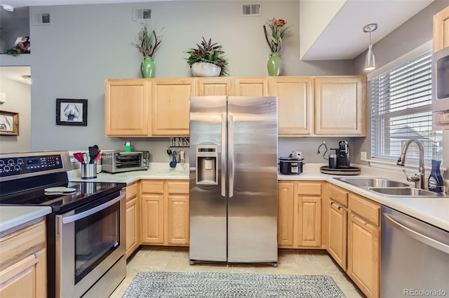 kitchen with light brown cabinets, appliances with stainless steel finishes, light tile patterned floors, and sink