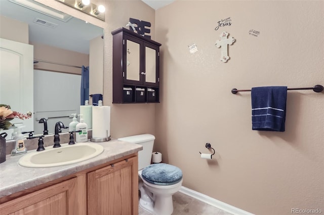 bathroom with vanity, tile patterned flooring, and toilet