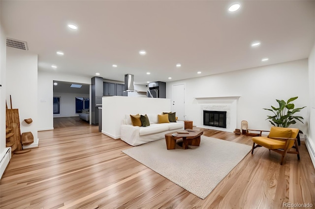 living room with light hardwood / wood-style floors and a premium fireplace