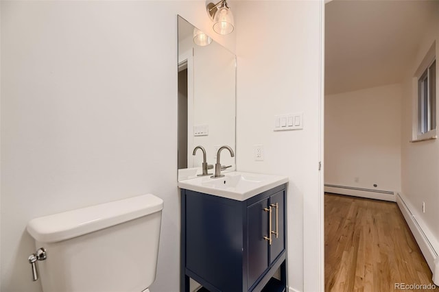 bathroom featuring hardwood / wood-style floors, vanity, toilet, and a baseboard radiator