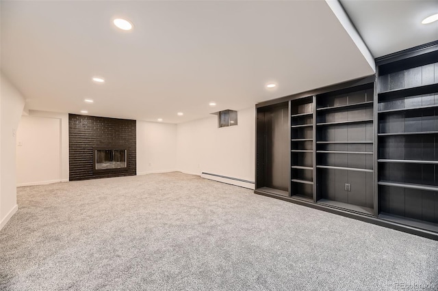 unfurnished living room with baseboard heating, a fireplace, and carpet floors