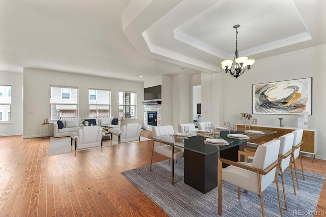 dining space with a fireplace, a tray ceiling, and a wealth of natural light