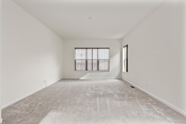 spare room featuring light colored carpet