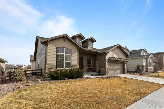 craftsman inspired home featuring a garage and a front lawn