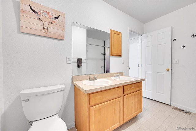 2791 Quarterland St, Strasburg, CO 80136 - bathroom featuring double vanity, toilet, baseboards, and a shower