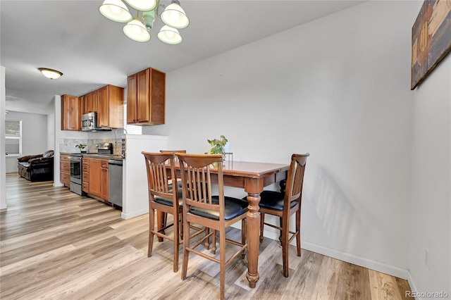 2791 Quarterland St, Strasburg, CO 80136 - dining room featuring light wood-style floors, a chandelier, and baseboards