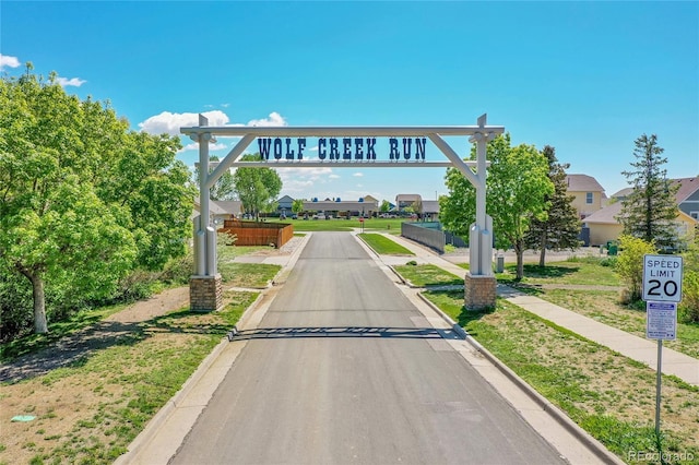 2791 Quarterland St, Strasburg, CO 80136 - view of asphalt road with curbs, traffic signs, a residential view, and sidewalks