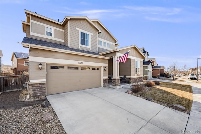 craftsman house with stone siding, concrete driveway, fence, and an attached garage