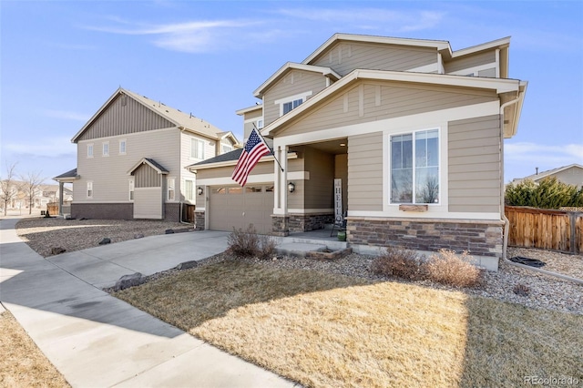 craftsman-style home with stone siding, fence, and concrete driveway