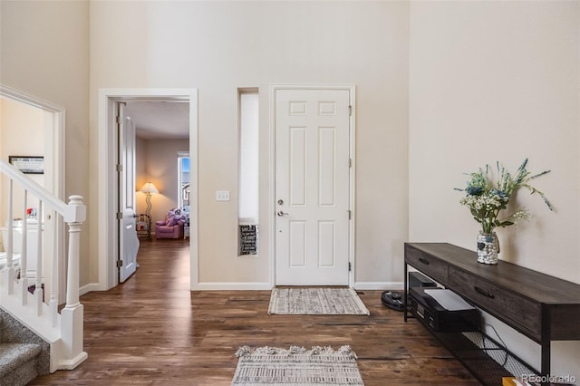 foyer with stairs, wood finished floors, and baseboards