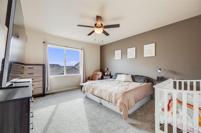 carpeted bedroom with ceiling fan and baseboards