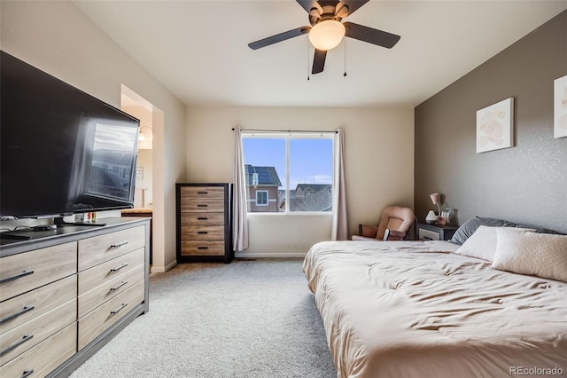 bedroom with light carpet, ceiling fan, and baseboards