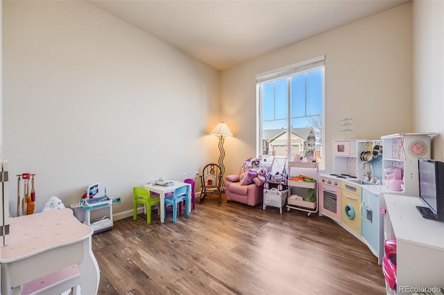 recreation room featuring baseboards and wood finished floors