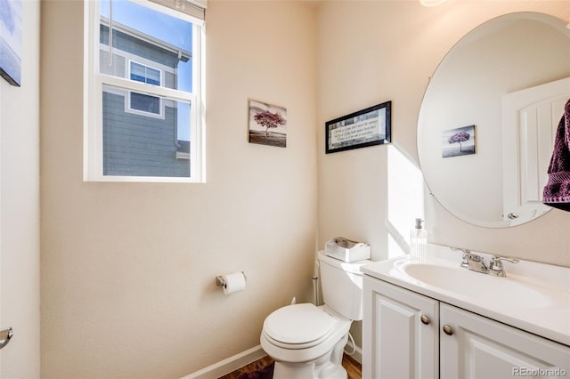 bathroom with vanity, toilet, and baseboards