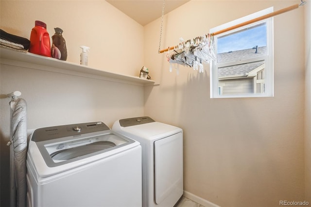 clothes washing area with laundry area, baseboards, and separate washer and dryer