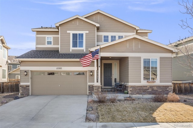 craftsman inspired home featuring a garage, stone siding, fence, and concrete driveway