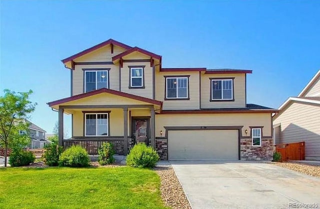 craftsman house with a garage, covered porch, and a front lawn