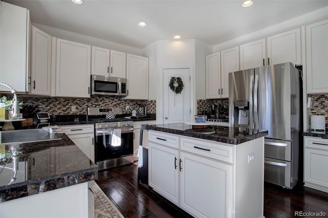 kitchen with stainless steel appliances, a center island, sink, and white cabinets