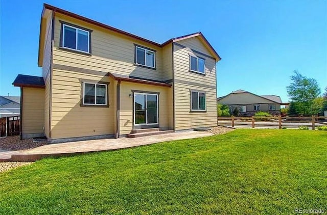 rear view of house with a patio and a lawn