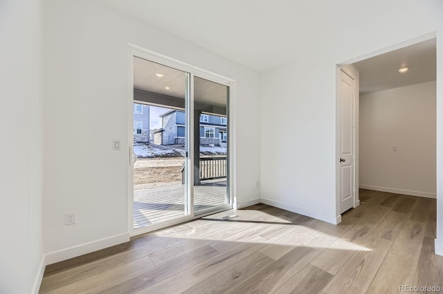 unfurnished room featuring light wood-type flooring and baseboards