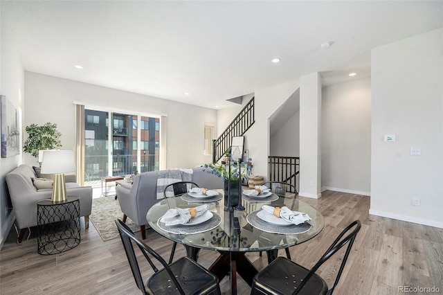 dining room with stairs, recessed lighting, light wood-type flooring, and baseboards