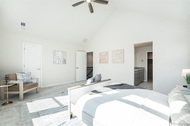 bedroom with ensuite bath, visible vents, light colored carpet, and high vaulted ceiling