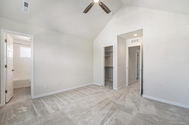 unfurnished bedroom with light carpet, visible vents, a spacious closet, and baseboards