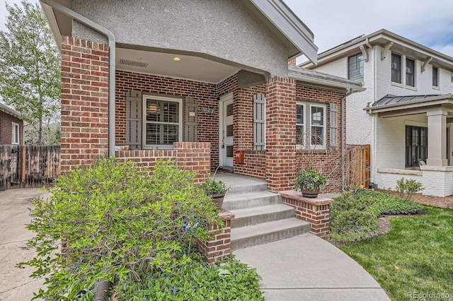entrance to property with fence and brick siding