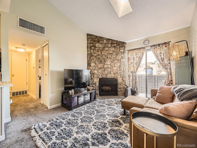 living room with carpet floors, a textured ceiling, lofted ceiling with skylight, and a fireplace