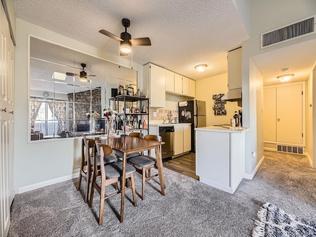 dining space with ceiling fan, sink, dark carpet, and a textured ceiling