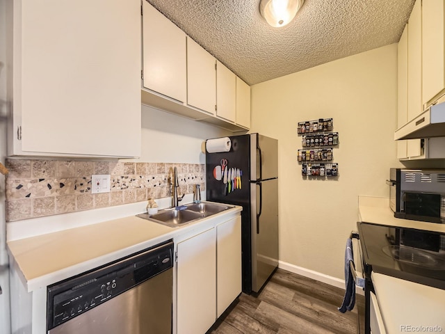 kitchen featuring appliances with stainless steel finishes, sink, white cabinets, a textured ceiling, and dark hardwood / wood-style floors